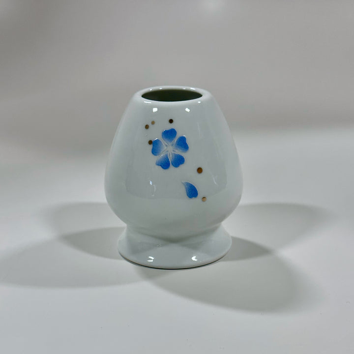 Blue flower patterned matcha whisk stand on white backdrop