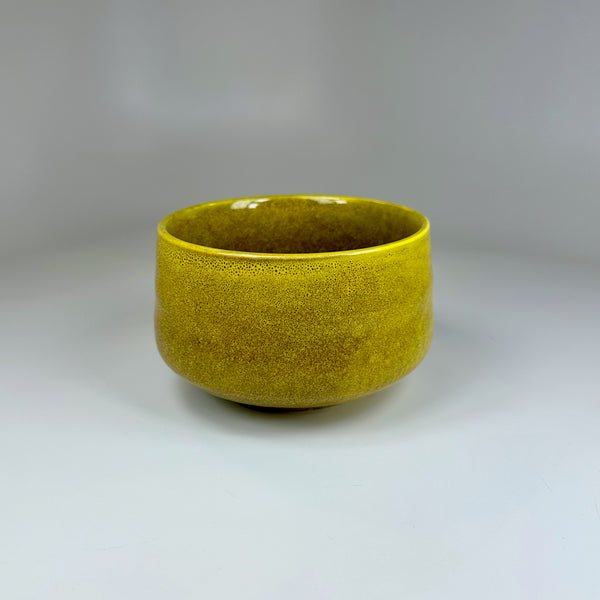 Desert yellow ceramic matcha bowl with warm earthy tones.